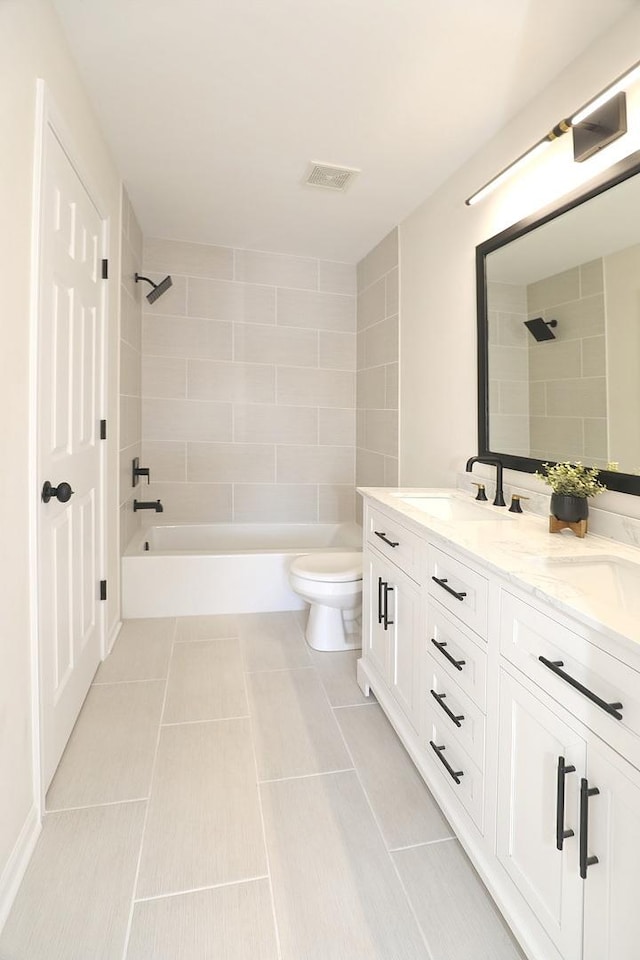 bathroom with double vanity, bathtub / shower combination, a sink, and toilet