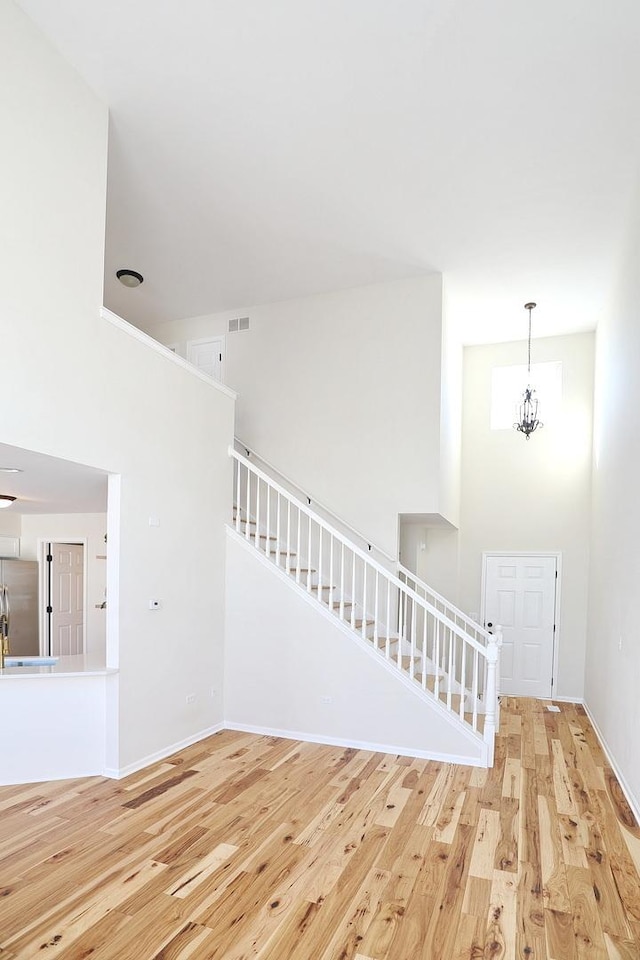 unfurnished living room featuring visible vents, wood finished floors, and stairs