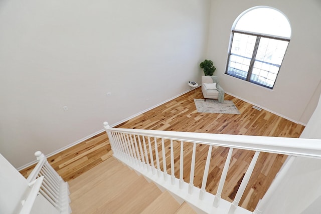 staircase featuring baseboards and wood finished floors