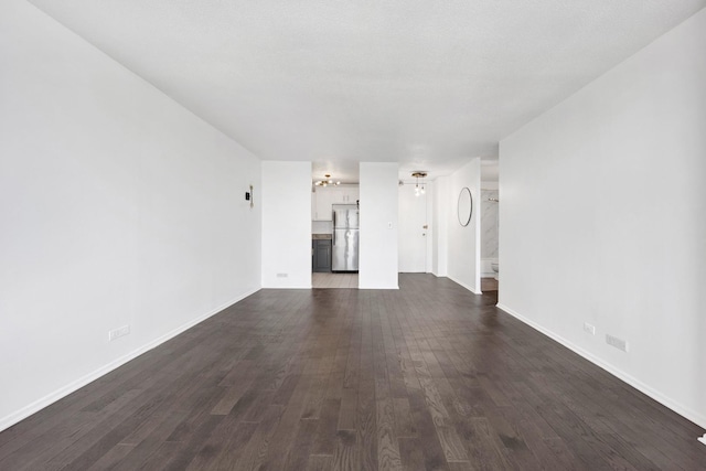 unfurnished living room featuring dark wood-style floors and baseboards