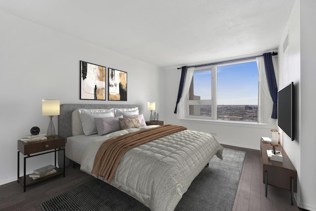 bedroom with visible vents, dark wood finished floors, and baseboards