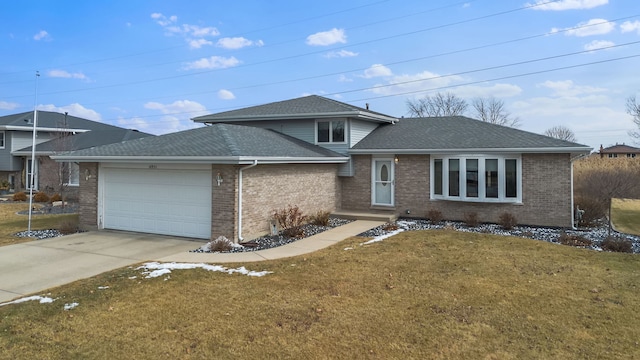 tri-level home with a garage, concrete driveway, roof with shingles, a front lawn, and brick siding