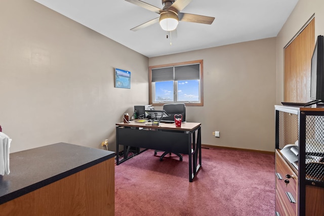 carpeted home office with baseboards and a ceiling fan