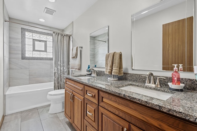 full bath featuring toilet, double vanity, visible vents, and a sink