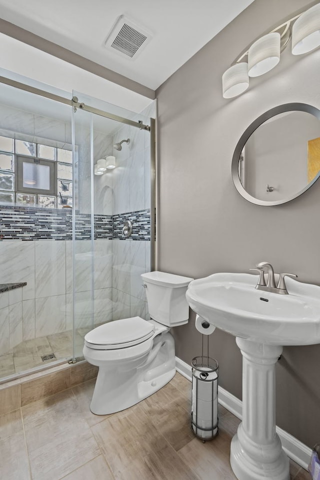 full bath featuring visible vents, toilet, a shower stall, wood finished floors, and baseboards