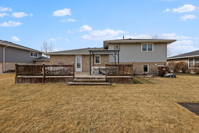 back of house featuring brick siding, a lawn, a pergola, and a wooden deck