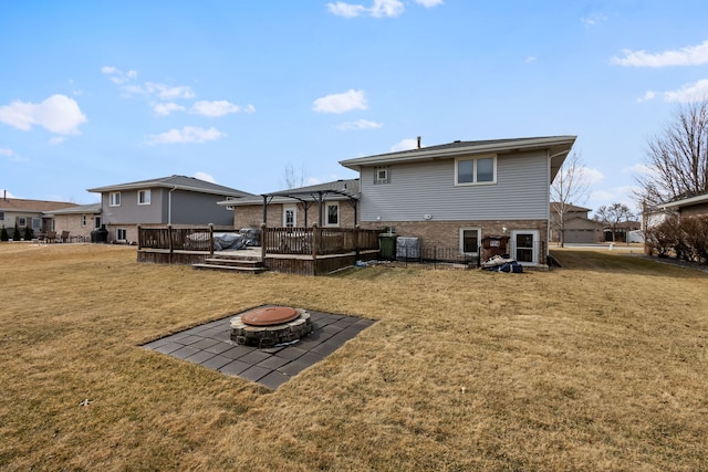 back of property with a deck, a lawn, a fire pit, and a pergola