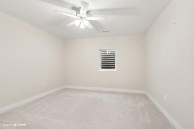 empty room with light colored carpet, ceiling fan, visible vents, and baseboards