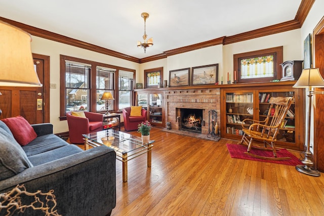 living area featuring crown molding, a fireplace, and hardwood / wood-style floors