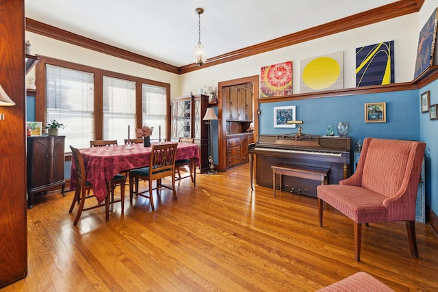 dining area featuring crown molding and light wood-style floors