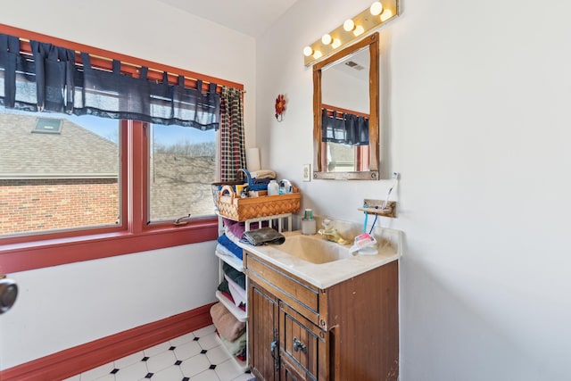 bathroom with vanity, baseboards, and tile patterned floors