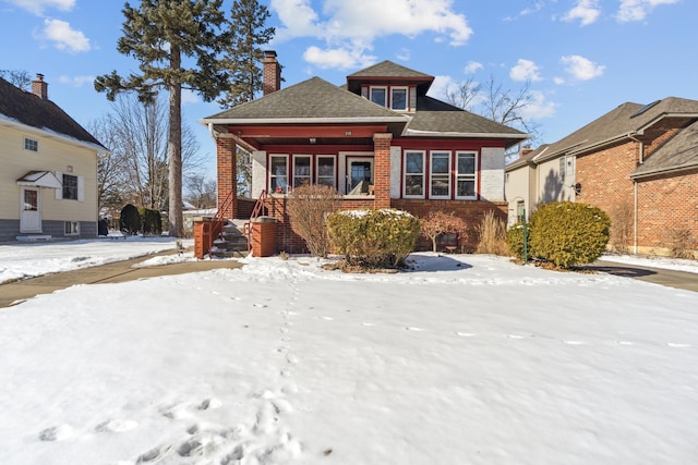 bungalow featuring brick siding