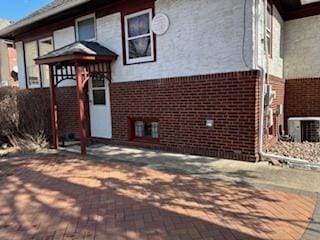 view of home's exterior with brick siding and central air condition unit