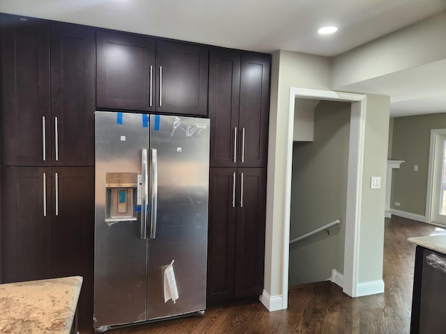 kitchen with dark brown cabinetry, baseboards, dark wood-type flooring, light stone countertops, and stainless steel appliances