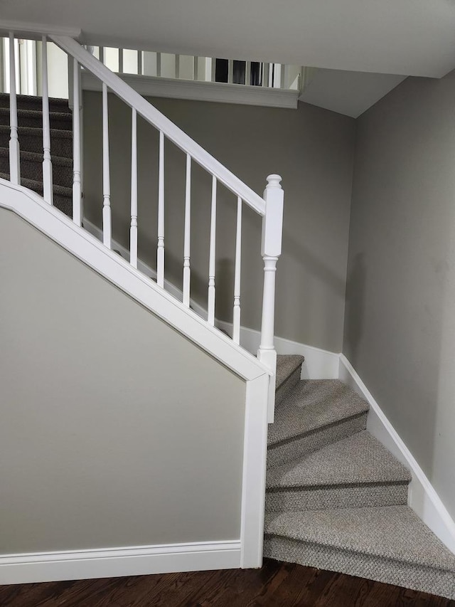 stairway featuring baseboards and wood finished floors