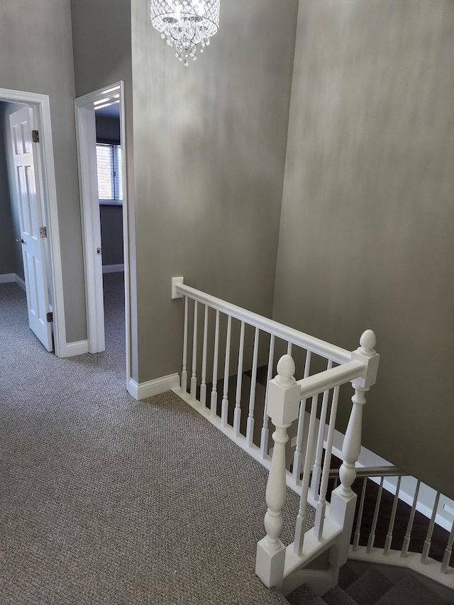 stairs featuring carpet floors, a chandelier, and baseboards