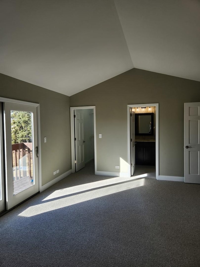 unfurnished bedroom with baseboards, lofted ceiling, ensuite bathroom, access to exterior, and carpet flooring