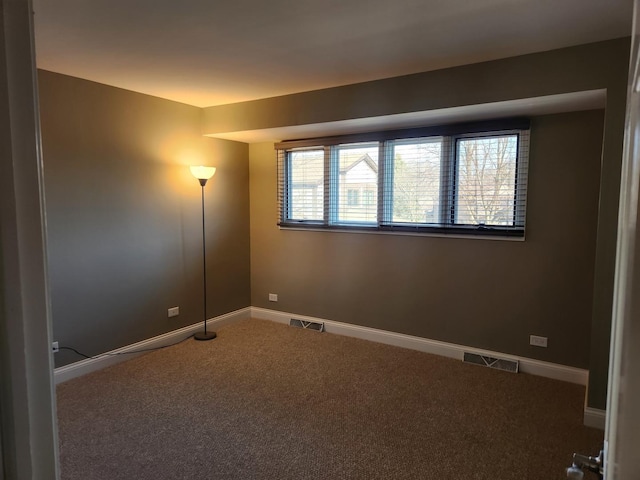 unfurnished room featuring carpet, visible vents, and baseboards