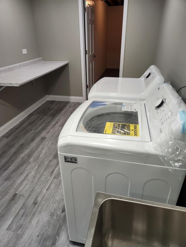 interior details featuring baseboards, washer and clothes dryer, and wood finished floors