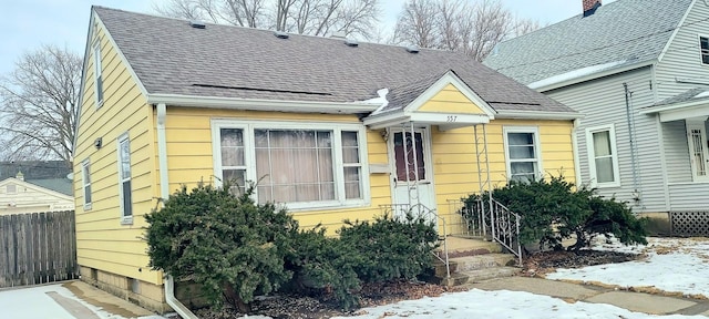 view of front of property featuring a shingled roof and fence