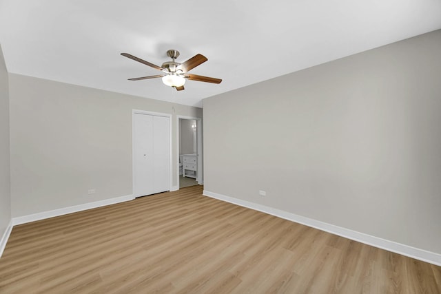 unfurnished bedroom featuring light wood-style flooring, a closet, baseboards, and a ceiling fan