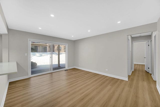 spare room featuring light wood finished floors, baseboards, and recessed lighting