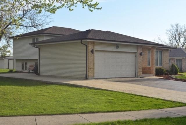 view of home's exterior with a lawn, driveway, and an attached garage