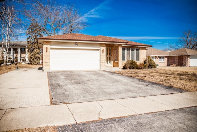 single story home featuring driveway, an attached garage, roof with shingles, and brick siding