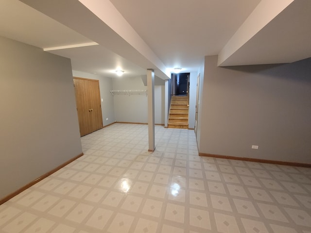 finished basement with light floors, baseboards, and stairs