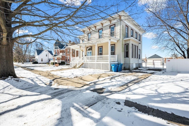 view of front of home with a garage, a residential view, fence, and a porch