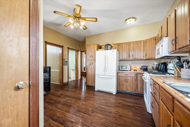 kitchen with white appliances, dark wood-style floors, brown cabinets, and light countertops