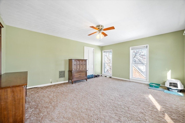 unfurnished room with carpet, a ceiling fan, and baseboards