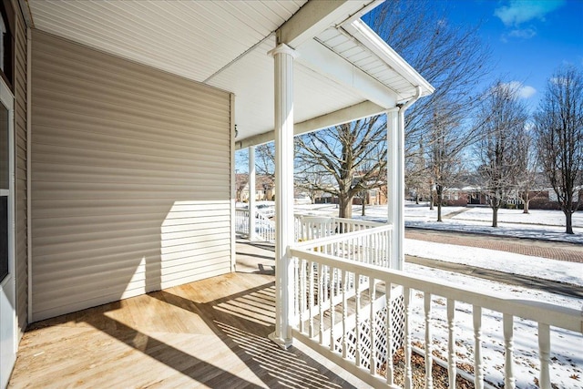 snow covered deck with covered porch