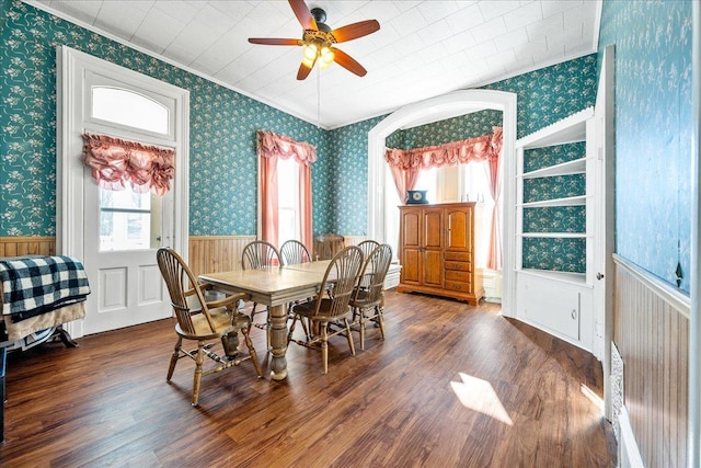 dining room featuring dark wood-style floors, wainscoting, and wallpapered walls