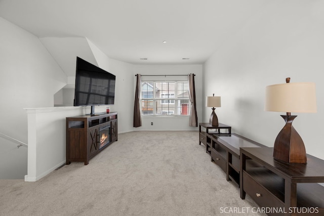 sitting room with light colored carpet and an upstairs landing