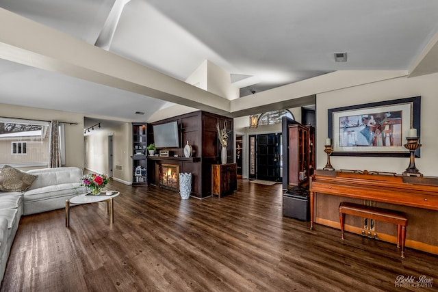 living area with vaulted ceiling, wood finished floors, visible vents, and baseboards