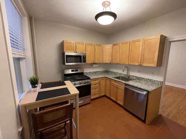 kitchen featuring a sink, appliances with stainless steel finishes, light brown cabinetry, and light countertops