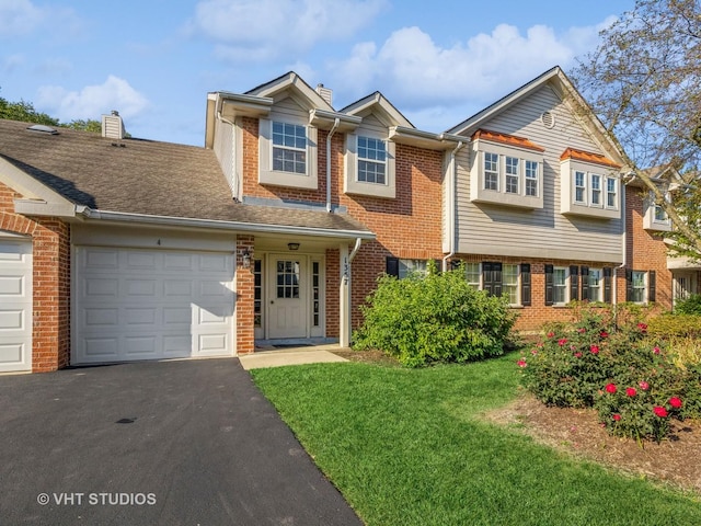 view of front of house with brick siding, driveway, a front yard, and a garage