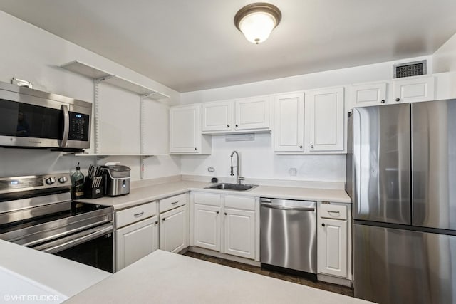 kitchen featuring appliances with stainless steel finishes, visible vents, a sink, and white cabinetry