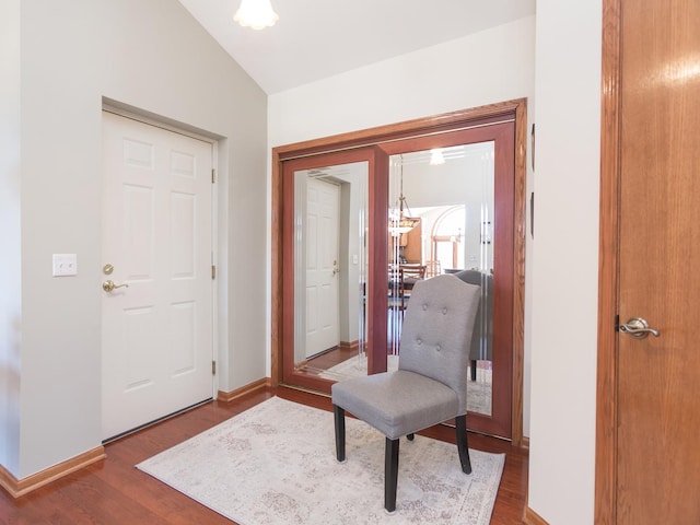 entrance foyer featuring lofted ceiling, baseboards, and wood finished floors