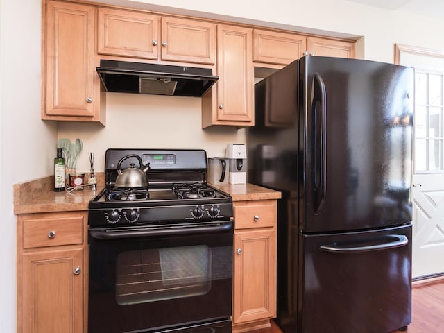 kitchen featuring black appliances, exhaust hood, light countertops, and light wood-style floors