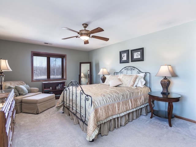 bedroom featuring a ceiling fan, light carpet, visible vents, and baseboards