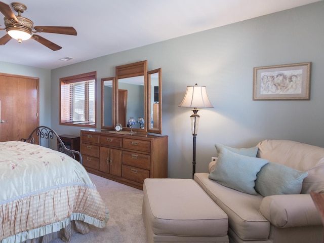 bedroom featuring light carpet, ceiling fan, and visible vents