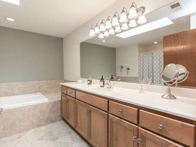 full bathroom with a skylight, visible vents, tile patterned floors, a garden tub, and vanity