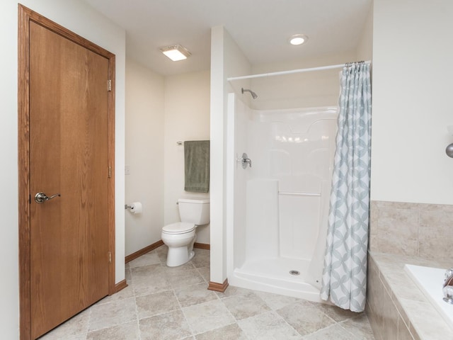 bathroom featuring a stall shower, a garden tub, toilet, and baseboards