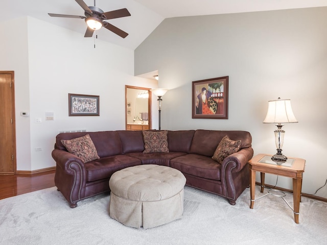 living area with a ceiling fan, high vaulted ceiling, and baseboards