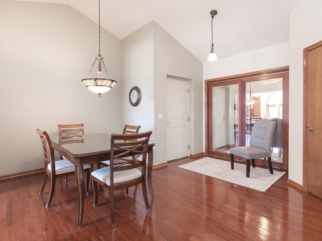 dining area with baseboards, vaulted ceiling, and wood finished floors