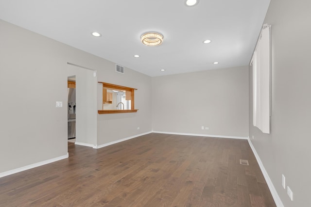 spare room featuring recessed lighting, a sink, visible vents, baseboards, and dark wood-style floors