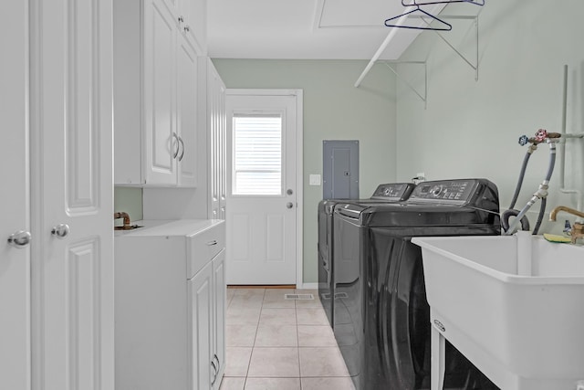 laundry room with cabinet space, light tile patterned floors, electric panel, independent washer and dryer, and a sink