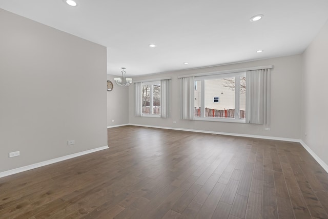 unfurnished room with dark wood-style floors, recessed lighting, a chandelier, and baseboards